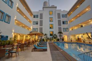 a hotel with a pool and chairs and a building at Hotel Vilmaris Breeze in Calangute