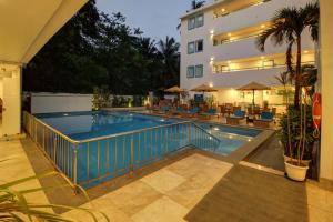 a swimming pool in front of a building at Hotel Vilmaris Breeze in Calangute