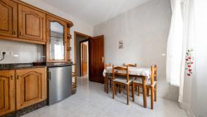 a kitchen with a table and chairs in a kitchen at Langosteira Beach, spacious apartment in Fisterra