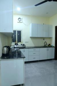 a kitchen with white cabinets and black counter tops at The Golden Farm in Jāmb +67 photos