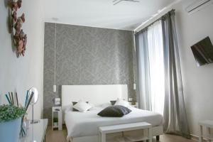 a bedroom with a white bed and a window at Come a Casa Pretty Apartment in Lido di Ostia