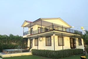 a house with a balcony on top of it at The Golden Farm in Jāmb