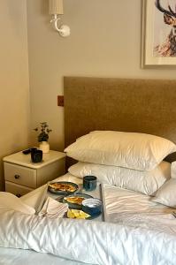 a bed with a tray of food on top of it at Cosy Cottage for Two in the Peak District with Parking in Onecote