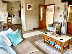 a living room with a couch and a table at Cosy Cottage for Two in the Peak District with Parking in Onecote