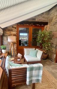 a living room with two chairs and a couch at Cosy Cottage for Two in the Peak District with Parking in Onecote