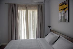 a bedroom with a bed and a large window at The ViewPoint VP3 in Mytilene