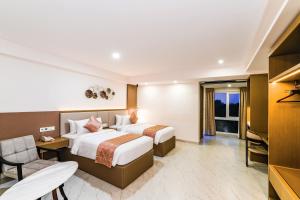 a hotel room with two beds and a television at Hotel Star Place in Chennai