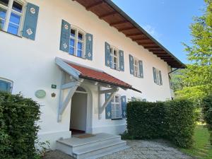 a white house with blue windows and a porch at Ferienwohnung Schwark Haus Elisabeth in Aschau im Chiemgau