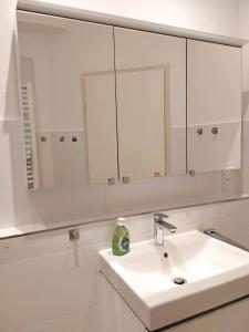 a white bathroom with a sink and a mirror at Ferienwohnung Schwark Haus Elisabeth in Aschau im Chiemgau
