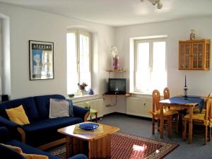 a living room with a blue couch and a table at Ferienwohnung Schwark Haus Elisabeth in Aschau im Chiemgau