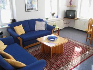 a living room with blue couches and a coffee table at Ferienwohnung Schwark Haus Elisabeth in Aschau im Chiemgau +6 photos