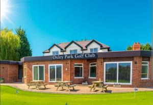 a brick building with picnic tables in front of it at Valgor -3 Bedroom House-Sleeps 5 with free parking-Ideal for contractors, families and group stays-WV6 in Tettenhall