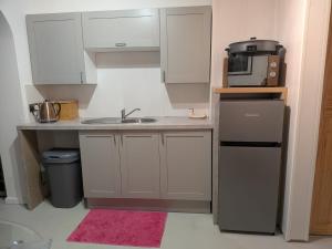 a small kitchen with a sink and a microwave at Sandham Hall Cottage in Sandown +6 photos