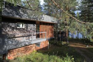 a brick house with a deck on the side of it at Tikankolo in Puumala