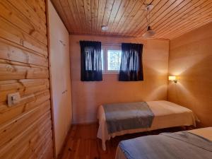a bedroom with two beds and a window at Tikankolo in Puumala