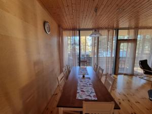 a dining room with a long table and a clock on the wall at Tikankolo in Puumala