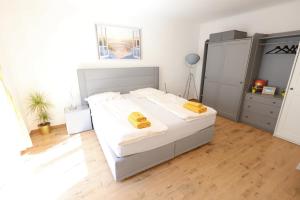 a bedroom with a bed with two yellow pillows on it at Hofgassenhaus LIMUN in Mörbisch am See