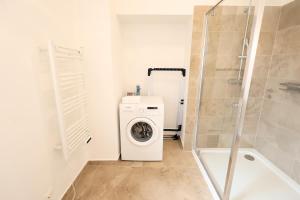 a bathroom with a washing machine and a shower at Hofgassenhaus LIMUN in Mörbisch am See +41 photos