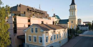 a building with a clock tower in a city at Lapland Hotels Oulu in Oulu