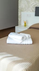 a stack of towels sitting on top of a bed at L'Eden di Nicolas in San Costantino Calabro +106 photos