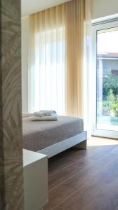 a bedroom with a bed and a large window at L'Eden di Nicolas in San Costantino Calabro