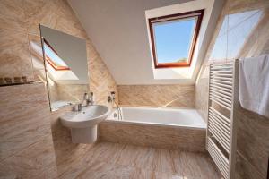 a bathroom with a sink and a bath tub at Penzión Lapáš u Hoffera in Nitra