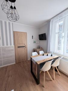 a dining room with a table and white chairs at Willa Azur blisko plaży, centrum Mielna in Mielno