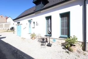 a white house with two chairs and a table at Hofgassenhaus LIMUN in Mörbisch am See