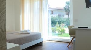 a bedroom with a bed and a large window at L'Eden di Nicolas in San Costantino Calabro