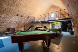 a room with a pool table and a staircase at Le Magasin à Poudre in Rocroi