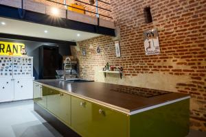 a kitchen with a counter and a brick wall at Le Magasin à Poudre in Rocroi