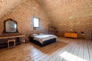 a bedroom with a bed in a brick wall at Le Magasin à Poudre in Rocroi