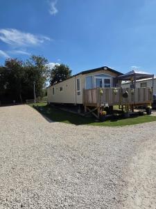 a mobile home with a porch on a gravel driveway at Rody's Cosy Corner in Crowle