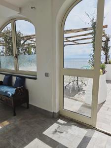 a room with two windows and a view of the ocean at Hostel Brikette in Positano