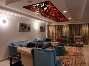 a large living room with blue couches and a red ceiling at Silva Montana in Mount Kenya