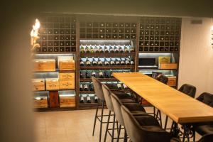 a room with a long table and chairs and wine racks at Hotel Planinka in Ljubno