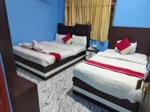 two beds in a room with blue walls at Hotel Aahar chitawan in Bharatpur