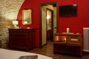 a room with a red wall with a dresser and a mirror at Locanda Osteria Marascia in Calolziocorte