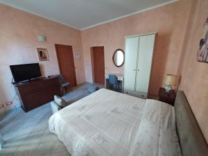 ein Schlafzimmer mit einem großen Bett und einem Fernseher in der Unterkunft Agorà-Akrai B&B in Palazzolo Acreide