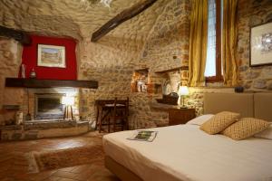 a bedroom with a bed and a fireplace at Locanda Osteria Marascia in Calolziocorte