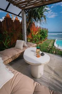 a patio with a white table and a view of the ocean at Bubble 2 - Sunset Private Pool Dome Uluwatu in Uluwatu