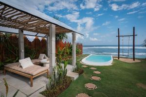 a backyard with a hot tub and a couch and a chair at Bubble 2 - Sunset Private Pool Dome Uluwatu in Uluwatu