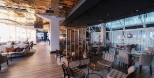 a lobby with chairs and tables in a building at Lapland Hotels Oulu in Oulu