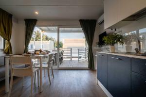 a kitchen and dining room with a table and chairs at Club del Sole La Risacca Family Collection in Porto SantʼElpidio
