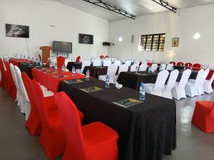 a conference room with tables and red chairs at Silva Montana in Mount Kenya