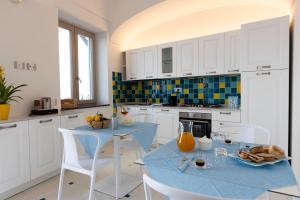 a kitchen with a table and chairs with a blue table at Borgo Sant'Anna in Amalfi