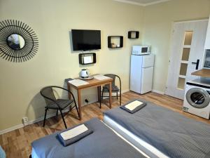 a room with two beds and a table and a microwave at Penzión Šariš in Prešov