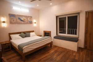 a bedroom with a bed and a large window at Omaya Vista in Mukteshwar