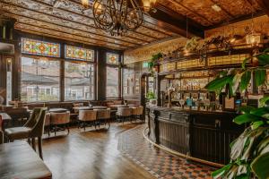 a restaurant with a bar with tables and chairs at The Crown & Greyhound by Innkeeper's Collection in London