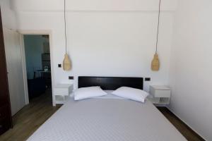a bedroom with a white bed with two white pillows at La casa nel campo in Syros Island National Airport